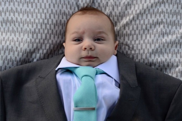 Un neonato travestito da manager con tanto di giacca e cravatta di papà
